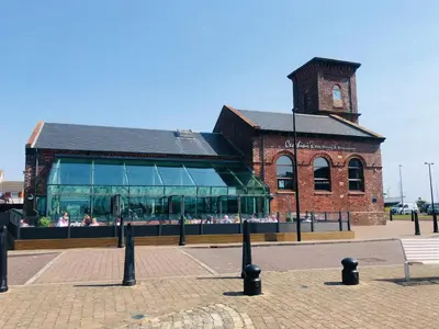 a brick building with a clock tower in front of it at South Beach Apartment in Ardrossan