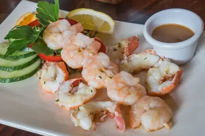 a plate with shrimp and a salad and dipping sauce at The Clachan Inn in Drymen