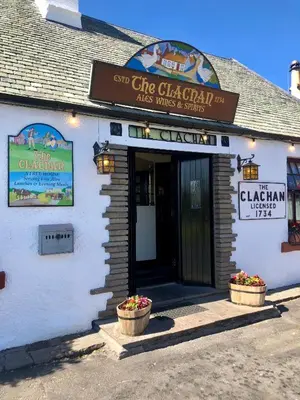 a white building with a sign that reads the chicago clam grill at The Clachan Inn in Drymen