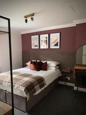 a bedroom with a large bed and a mirror at Lochside Guest House in Arrochar