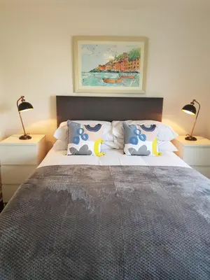 a bedroom with a large bed with two lamps at Carnegie Place in East Kilbride
