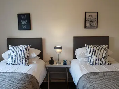 two beds sitting next to each other in a bedroom at Carnegie Place in East Kilbride