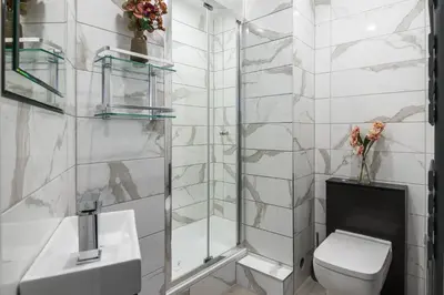 a bathroom with a shower and a toilet and a sink at Spacious newly refurbished central apt in Edinburgh