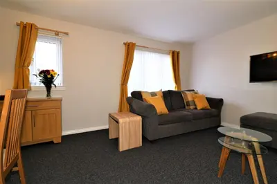 a living room with a couch and a table at Signature- Connelly House in Motherwell