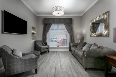 a living room with a couch and a tv at The Alexander - Donnini Deluxe in Prestwick