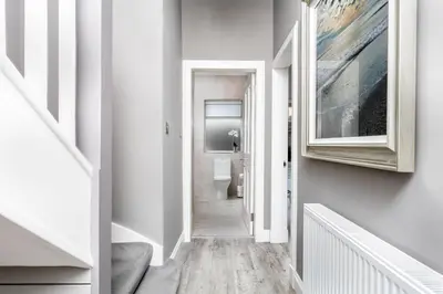 a hallway with a toilet and a painting on the wall at The Alexander - Donnini Deluxe in Prestwick