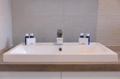 a white sink in a bathroom with a mirror at The Alexander - Donnini Deluxe in Prestwick