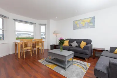 a living room with a couch and a table at Super Prime Park View Duloch by TBA in Dunfermline