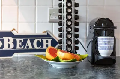 a bowl of fruit on a counter with a plate of oranges at Turnberry Serviced Apartments in Turnberry