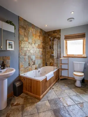 a bathroom with a tub and a toilet and a sink at Portbahn, Bruichladdich in Bruichladdich