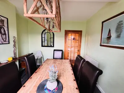 a dining room with a wooden table and leather chairs at Park Road Holiday Home - Spacious 3 bedroom house with garden near Edinburgh in Rosyth