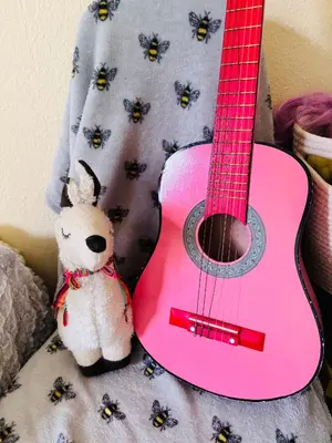 a stuffed teddy bear next to a pink guitar at Park Road Holiday Home - Spacious 3 bedroom house with garden near Edinburgh in Rosyth