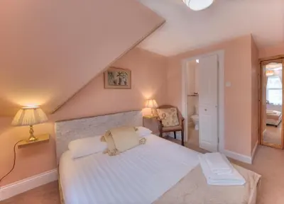 a bedroom with a large white bed and a chair at Kilchrenan House in Oban