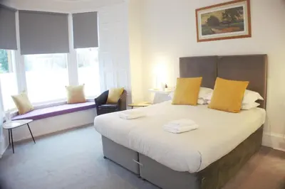 a bedroom with a large bed with yellow pillows at Barns Serviced Accommodation in Ayr