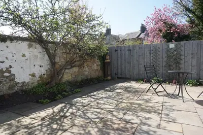a patio with a fence and a table and chairs at Barns Serviced Accommodation in Ayr