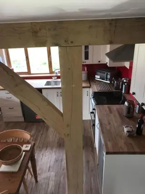a kitchen with white cabinets and a wooden counter top at Tigh a Chabar in Lochaline