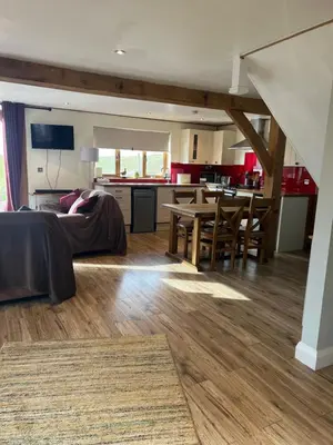 a living room and kitchen with a bed and a table at Tigh a Chabar in Lochaline