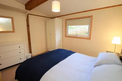 a bedroom with a large bed and a window at Clamshell Lodge in Otter Ferry