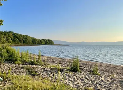 a beach next to a body of water at Clamshell Lodge in Otter Ferry