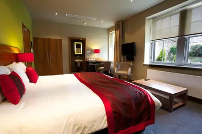 a hotel room with a large bed and a desk at Orocco Pier in Queensferry