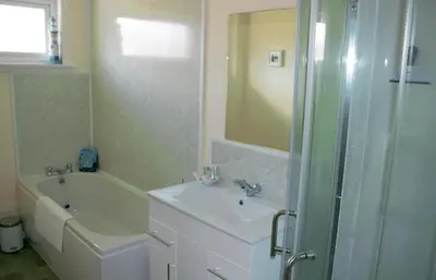 a bathroom with a sink and a tub and a shower at The Glebe, Am Fasgadh in Bowmore