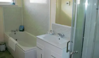 a bathroom with a sink and a tub and a shower at The Glebe, Am Fasgadh in Bowmore