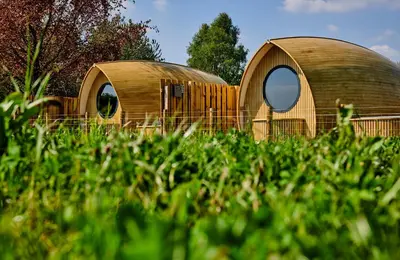 a wooden house with a round window in the grass at Luxury Hideaways in Keilour