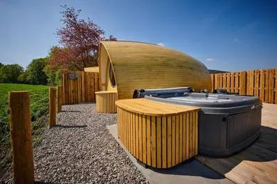 a hot tub sitting next to a wooden fence at Luxury Hideaways in Keilour