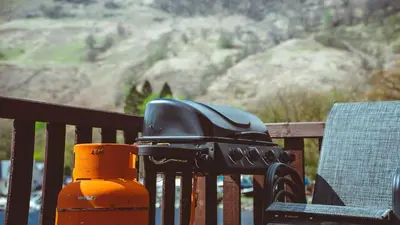 a helmet sitting on a fence next to a chair at Bonnie Banks Lodge Ardlui in Ardlui