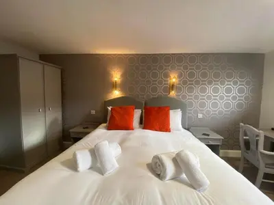 a bedroom with a white bed with three pillows on it at Achray House Restaurant with Rooms in Saint Fillans