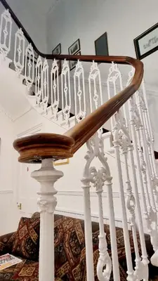a stair case with white railings and a wooden railing at The Guards Hotel in Edinburgh