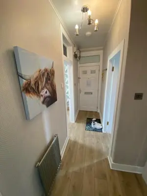 a hallway with a painting of a cow on the wall at Modern Quiet City Center Airport 2 Bedroom Apartment in Edinburgh