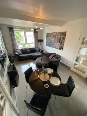 a living room with a table and chairs at Modern Quiet City Center Airport 2 Bedroom Apartment in Edinburgh