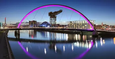 a pink bridge over a body of water at Bright and Cosy West End Apartment in Glasgow