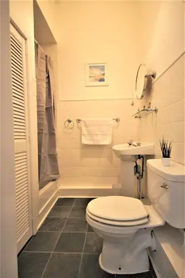 a white bathroom with a toilet and a sink at Bright and Cosy West End Apartment in Glasgow
