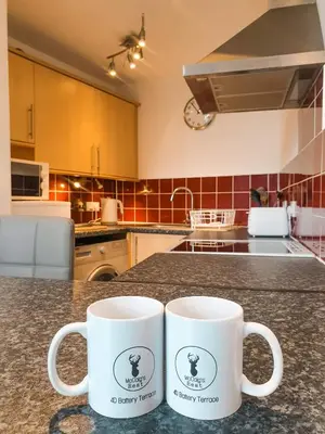 two coffee mugs sitting on a counter in a kitchen at Apartment D 4 Battery Terrace Oban in Oban