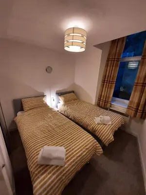 two beds in a small room with a window at Apartment D 4 Battery Terrace Oban in Oban