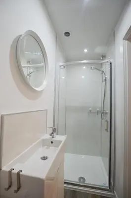 a white bathroom with a shower and a sink at Fairhaven, Oban Town Centre in Oban
