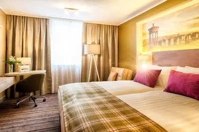 a hotel room with a bed and a desk at Leonardo Hotel Edinburgh Haymarket in Edinburgh