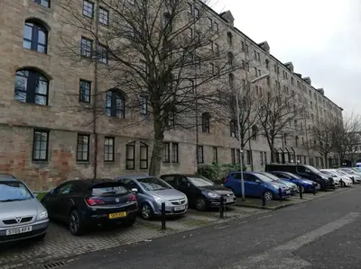 a row of cars parked in front of a building at Stylish Merchant City Flat in Glasgow