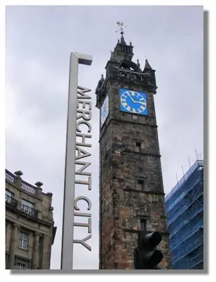 a tall clock tower with a blue clock on it at Stylish Merchant City Flat in Glasgow