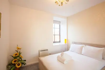 a bedroom with a bed with a towel on it at Stylish Merchant City Flat in Glasgow