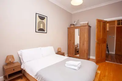 a bedroom with a white bed with two towels on it at Beautiful 2 Bed Apartment Rose St in Glasgow