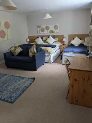 a living room with two beds and a couch at Boreland Farm in Dunscore
