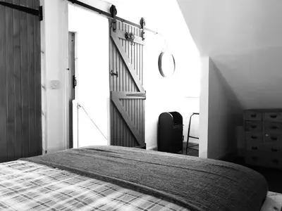 a bedroom with a large bed with a staircase at Fisher Holiday Cottage Ayrshire in Girvan