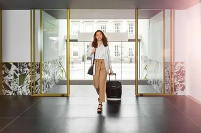 a woman walking down a hallway with her luggage at YOTEL Edinburgh in Edinburgh