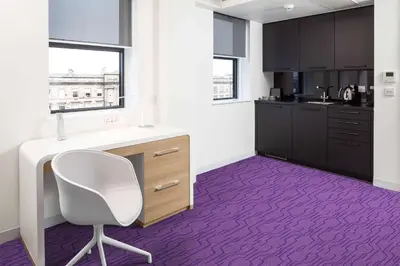 a kitchen with a white desk and a purple floor at YOTEL Edinburgh in Edinburgh