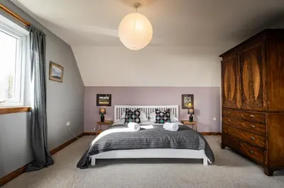 a bedroom with a bed and a large window at Shorefield, Bruichladdich in Bruichladdich