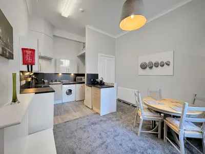 a kitchen and dining room with a table and chairs at Hayfield Apartment in Oban
