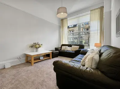 a living room with a couch and a table at Hayfield Apartment in Oban